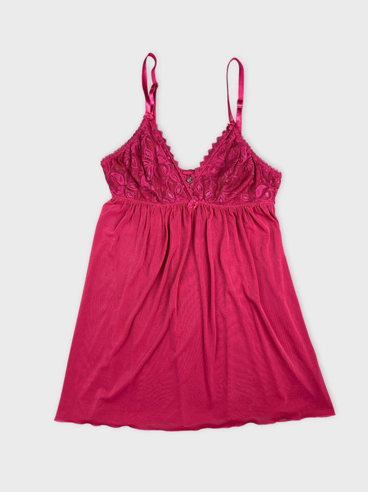 Front view of a pink lace-trimmed camisole top with adjustable straps.