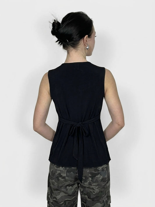 Back view of a sleeveless black top with a bow detail at the waist.