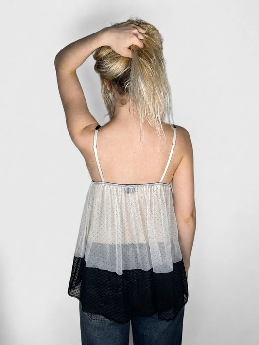 Back view of a women's tank top in cream and black with a polka dot pattern.
