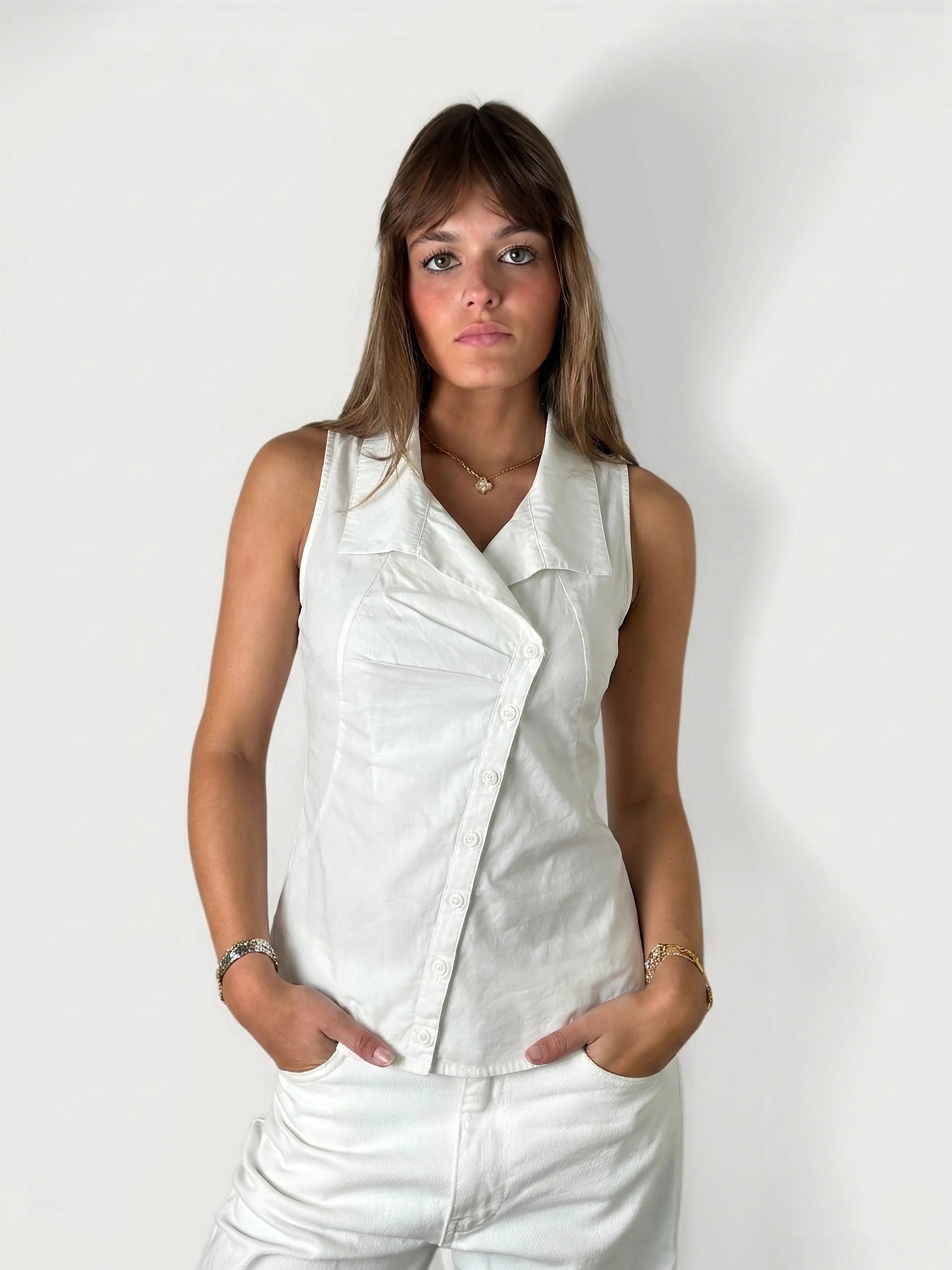 Back view of a white sleeveless top with button details.