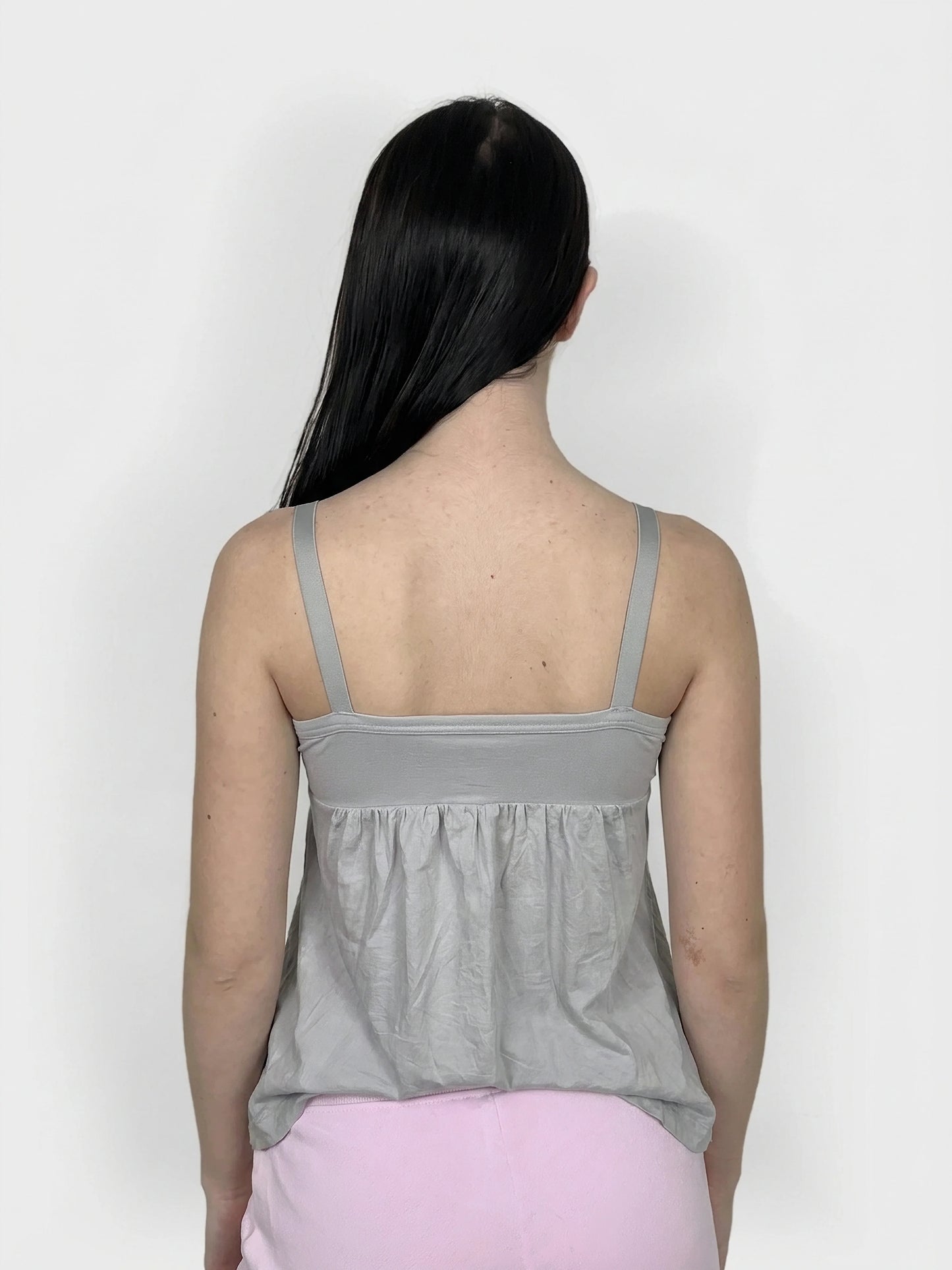 Back view of a grey women's upper body top with gathered detailing.
