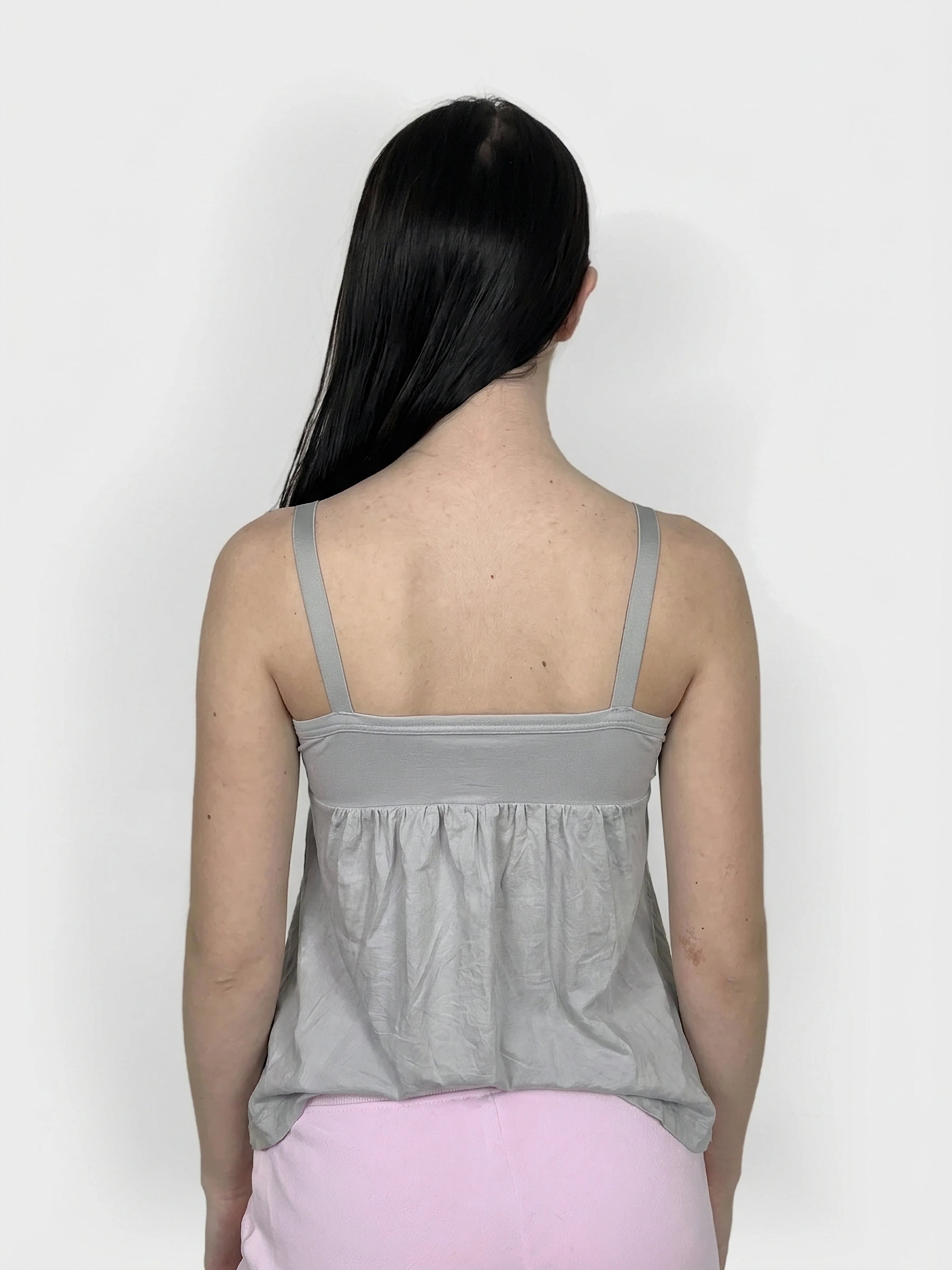 Back view of a grey women's upper body top with gathered detailing.