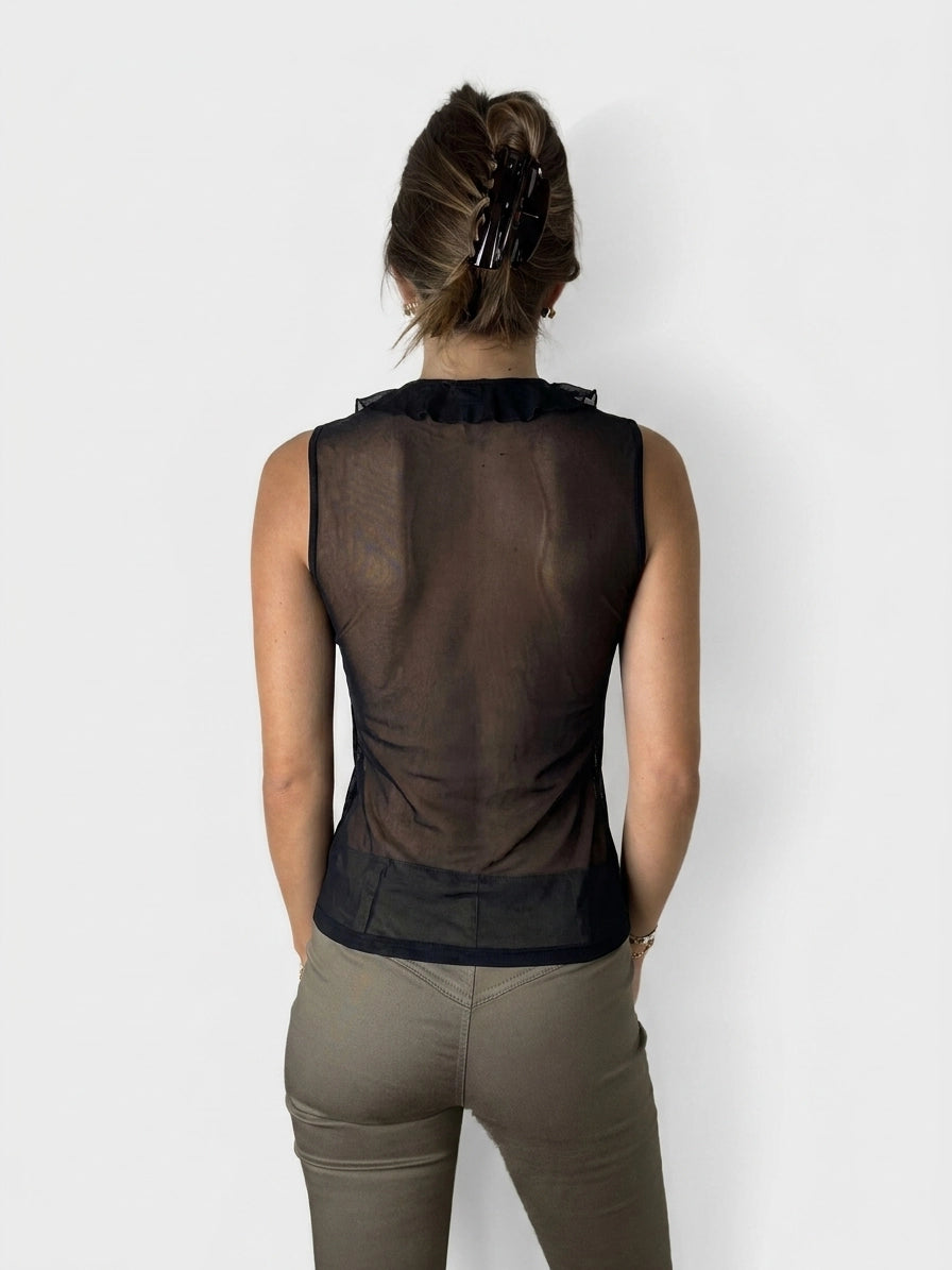 Back view of a women's black upper body top with a ruffled neckline.