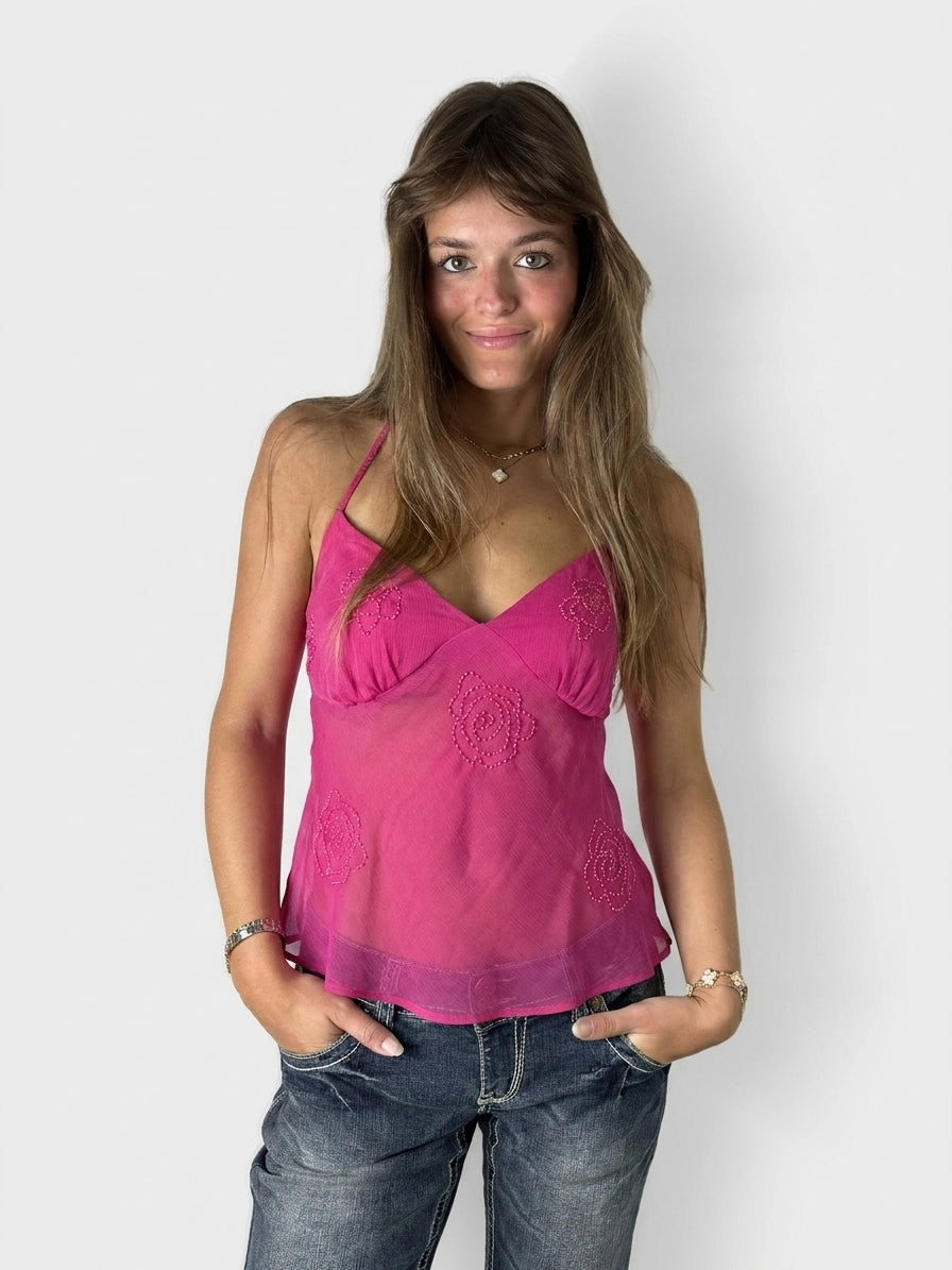 A pink upper body top featuring floral embroidery, shown in front view.