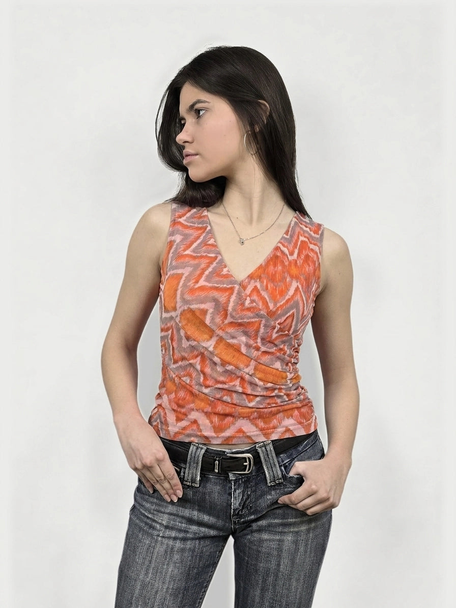 Front view of a sleeveless orange patterned top with a v-neckline.