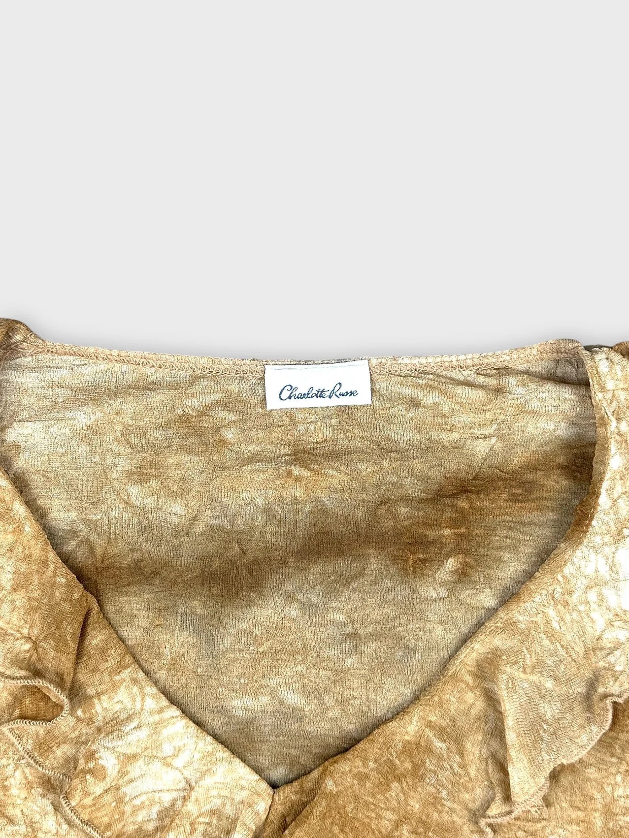 detail view of vintage upper long sleeve top in golden color with ruffled neckline